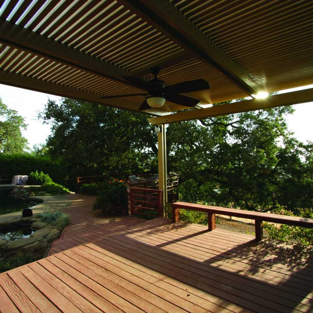 Cream louvered cover over wood deck poolside